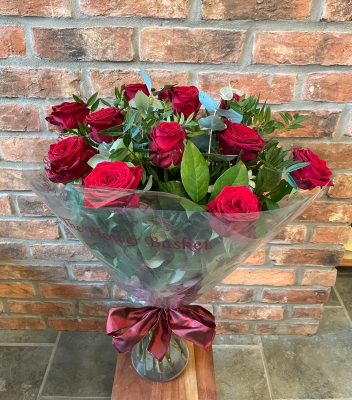 12 long stemmed luxury red roses in a vase